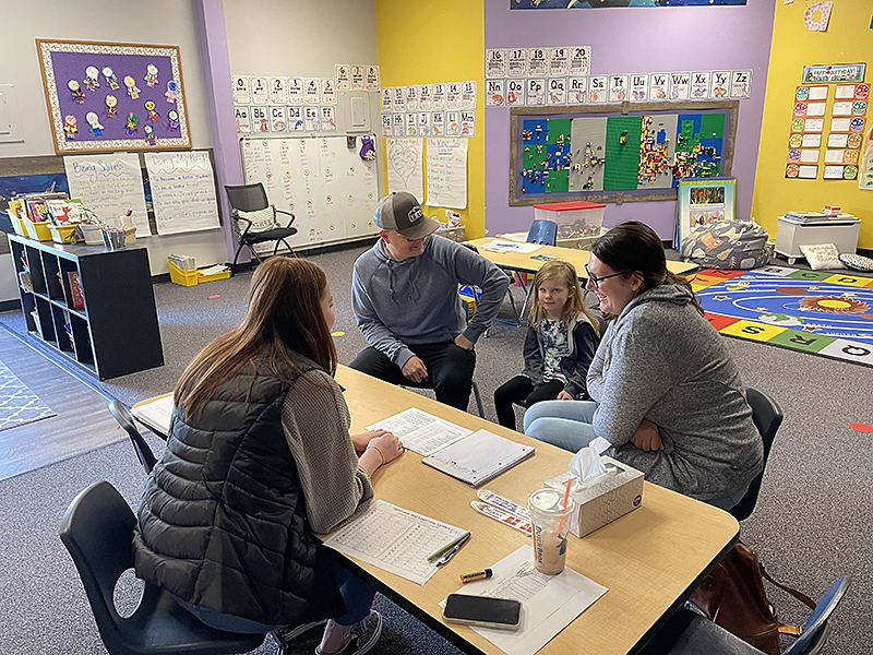 parents of an FRCS kindergarten student at a parent-teacher conference with their daughter's teacher