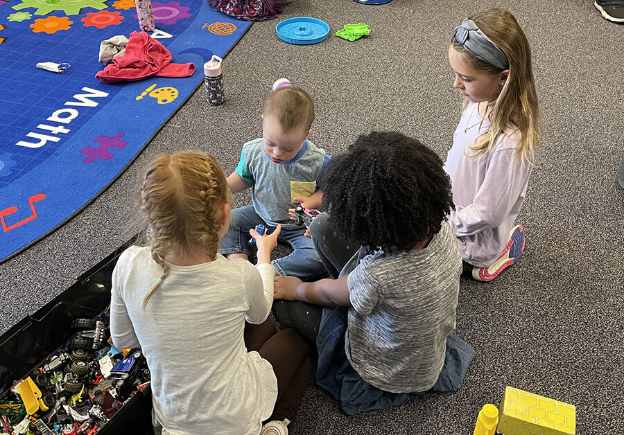 FRCS kindergarten girls play with a little boy whose family was touring the facility